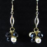 Goldplated fish hook earrings created with vintage black glass beads and vintage champagne-colored faux pearls dangling from a vintage gold jewelry piece.  The beads have been finished with goldplated bead caps. AVAILABLE